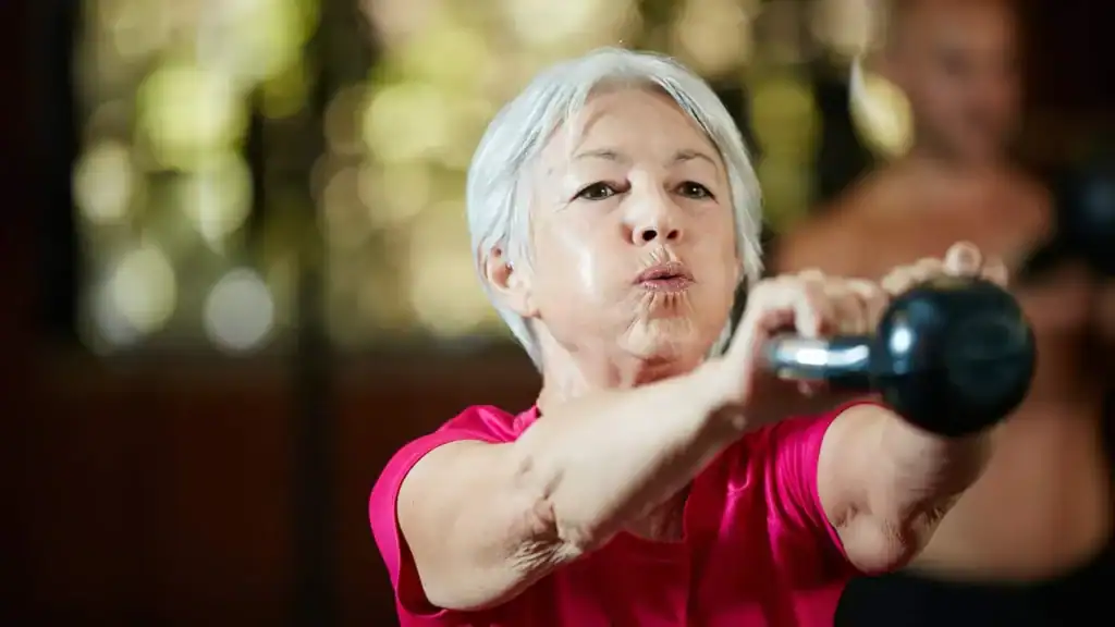Older woman doing weight training Horsham to help her strength and longevity 