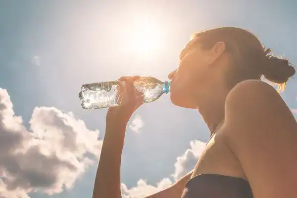 Image of woman drinking water to hydrate Horsham after run.